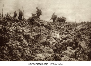 WWI. Western front battleground has been churned up by shell explosions so that it bears no resemblance to its peacetime appearance. Allied soldiers are in the background. Ca. 1915-18. Stock Illustration