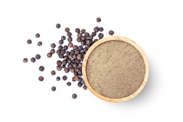 Ground pepper in wooden bowl and black peppercorns isolated on white background. Top view, flat lay. Foto Stok