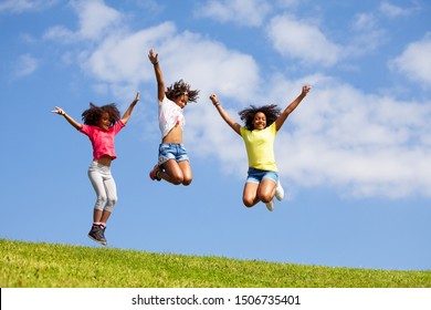 Group of kids jump high over blue sky and clouds, Stock image