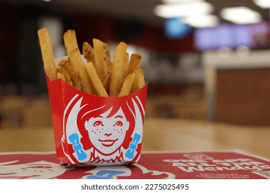 MIAMI FLORIDA USA - 02-26-2023
Wendy's Hot and Crispy french fries. Some out of focus restaurant interior in background. Foto Editorial Stock