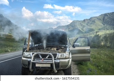 overheated car in the field, bright sunlight, steam under the hood. smoking engine in SUV car. Smoke coming out from overheat engine. Waiting car tow service. Mountain Altai, Russia