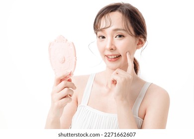 Portrait of Asian woman with a beautiful face and clean fresh smooth skin pimple press. Lovely female model with natural makeup in studio. Cosmetology, Facial treatment, Therapy and spa concept. 庫存照片