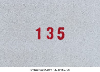 RED Number 135 on the white wall. Spray paint.one hundred thirty fiveone hundred thirty five
 Stock Photo