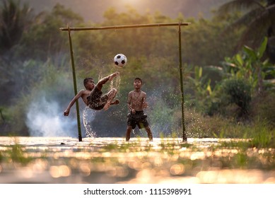 Asian Children Play Soccer In The River,Sport Plays An Important Role In Rural And Regional Thailand,Sport Are The Predominantly Or Exclusively Played In Rural Areas,Thailand Football. Stock Photo, Picture and Royalty Free