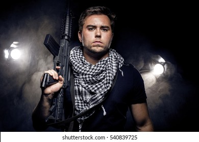 Soldier or mercenary wearing a shemagh with assault rifle, paintball or airsoft gun.  The image also depicts militarization of police or PMC private military companies Stock Photo