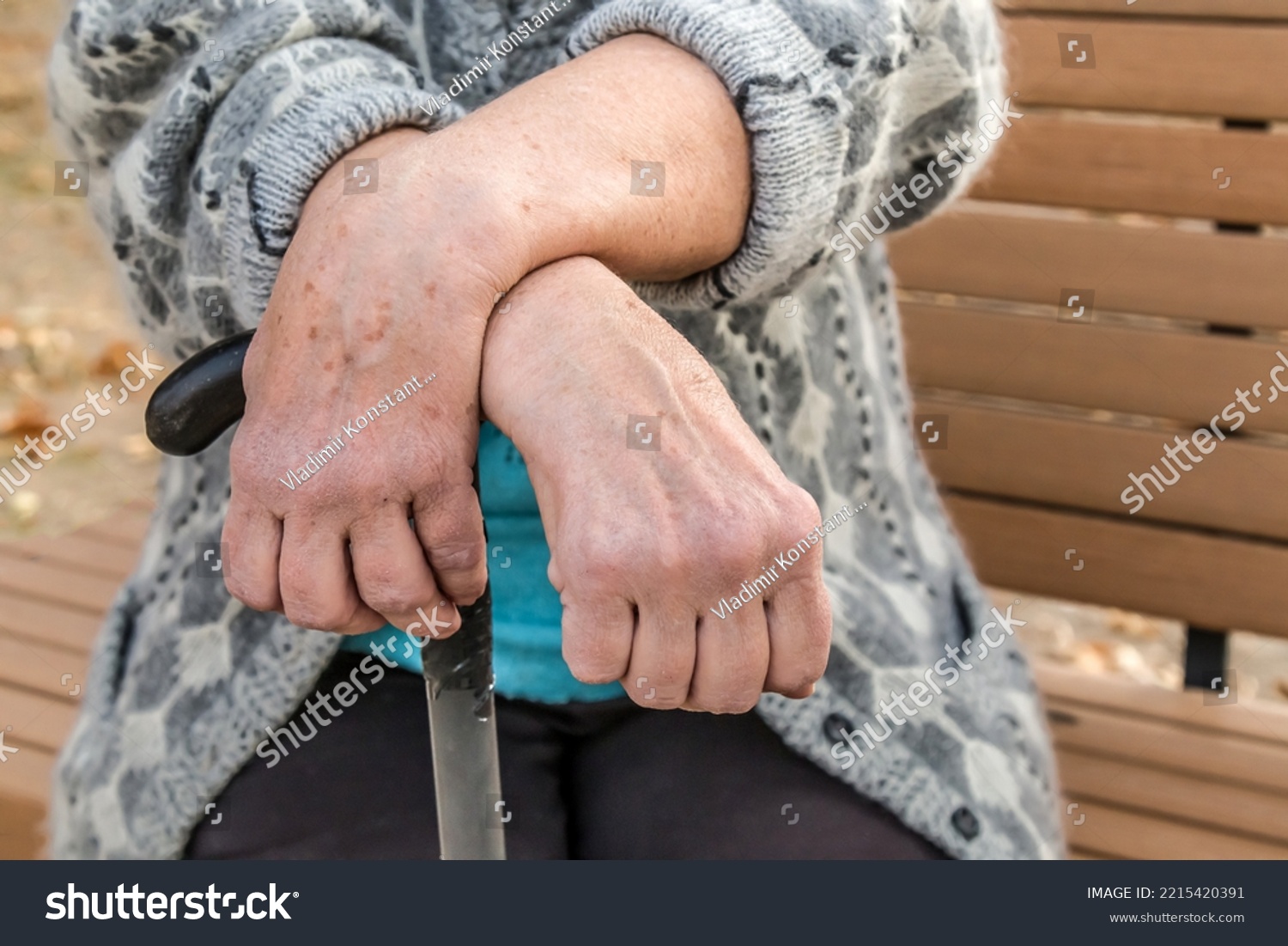 elderly-persons-hands-leaning-on-walking-stock-photo-2215420391