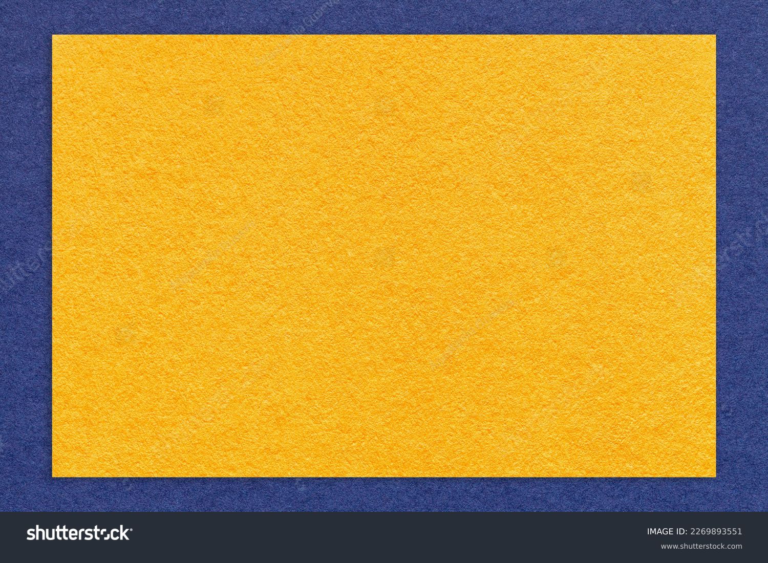 Texture of craft yellow color paper background with navy blue border, macro. Structure of vintage dense kraft golden cardboard with empty frame. Backdrop with copy space. స్టాక్ ఫోటో