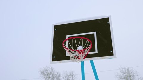 Basketball hoop covered with snow in winter. It's snowing outside. Stock Video