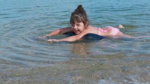 A child at sea. A kid in the sea. Happy little girl swims in the sea.