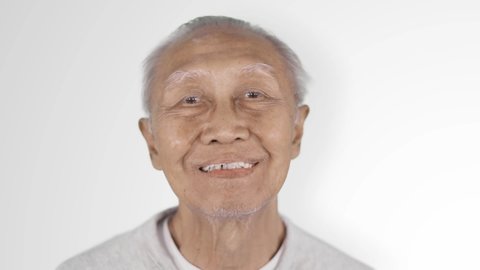 Slow motion of cheerful senior man with dentures laughing in the studio, isolated on white background Stock Video