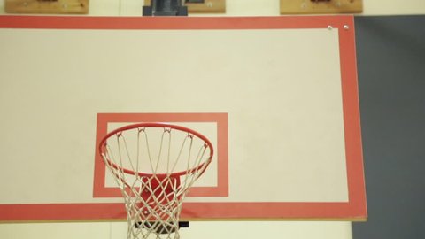 Стоковое видео: medium pan basketball hoop in school gymnasium